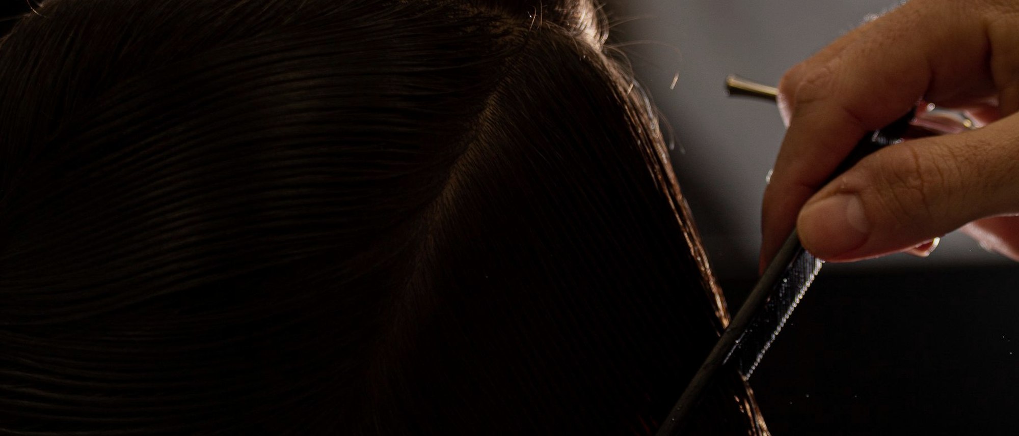 Stylist working a precision cut under warm light